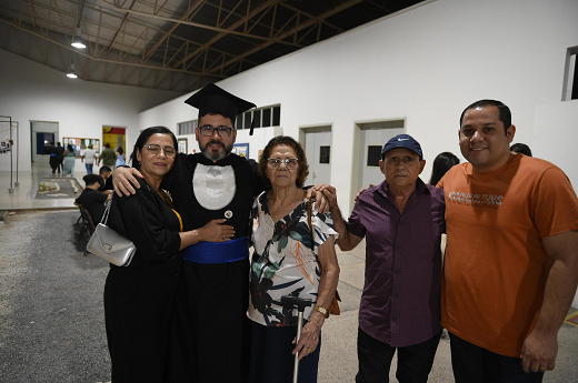 Imagem: Foto posada de um grupo de cinco pessoas, sendo duas mulheres e três homens. Um deles, Marco Túlio, veste beca de formando (Foto: Viktor Braga/UFC Informa)