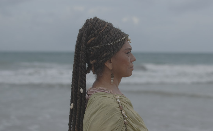 Imagem: O filme A rebelião dos jangadeiros aborda o movimento abolicionista liderado por Francisco José do Nascimento, o Dragão do Mar, e outros jangadeiros (Foto: Divulgação/ Gavulino Filmes) Imagem: Mulher negra de perfil, tendo o mar ao fundo