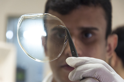 Pesquisador segura película transparente com uma pinça (Foto: Viktor Braga)