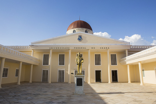 Imagem: fachada de um prédio na cor amarela com uma estátua de um homem ao centro