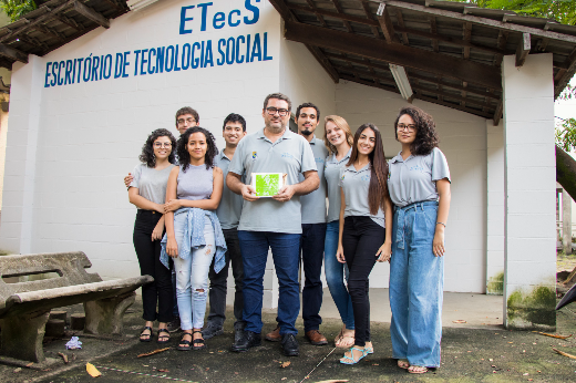 Imagem: estudantes e professor de Arquitetura e Urbanismo posam em frente à sede do Escritório de Tecnologia Social