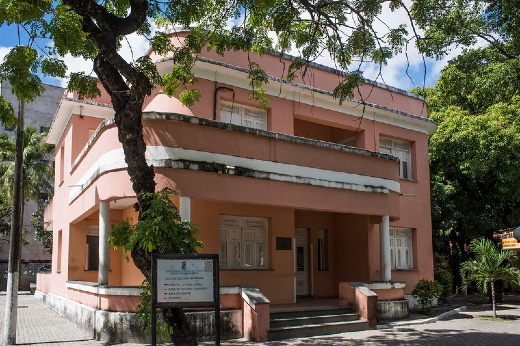 Imagem: Foto da fachada do prédio Casa de Cultura Britânica com uma árvore na frente