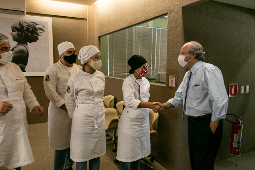 Imagem mostra reitor da UFC cumprimentando estudantes do curso de Gastronomia