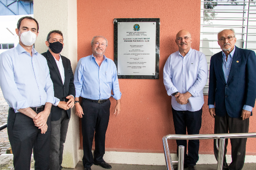 Foto mostra cinco homens, sendo três do lado esquerdo e dois do lado direito, com placa inaugurada no meio