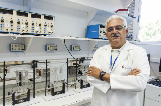 Imagem: professor vestido de bata branca em ambiente de laboratório