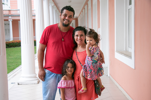 Imagem: homem, mulher e duas crianças pequenas posam para foto na Reitoria da UFC