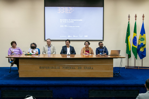 Imagem: pessoas sentadas na mesa do auditório da Reitoria