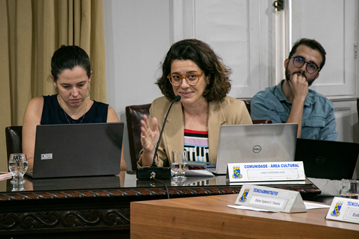 Imagem: Profª Kamila Bossato (ao centro, de blazer bege) fala aos conselheiros no plenário do CONSUNI. (Foto: Ribamar Neto/ UFC Informa)