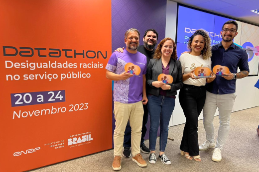 Imagem: cinco pessoas seguram troféus e posam para foto