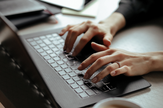 Imagem: mão femininas sobre teclado de laptop