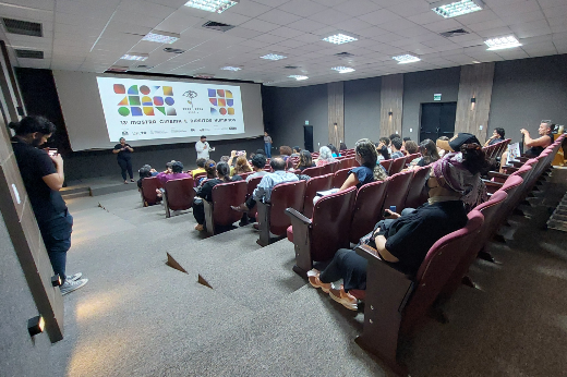 Imagem: sala de cinema com tela e público sentado