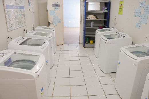 Imagem: máquinas de lavar em uma sala com piso branco quadriculado