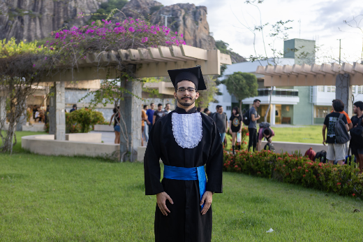 Imagem: estudante de beca posa para foto no Campus de Quixadá
