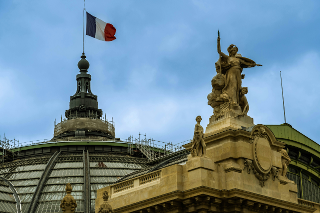 Imagem: Estátua de uma mulher segurando uma bandeira no topo de um edifício
