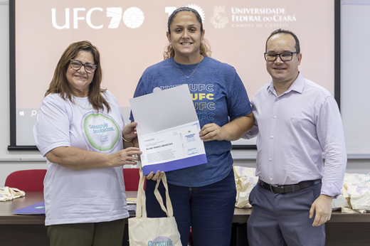 Certificados de reconhecimento valorizam o tempo de serviço e a dedicação dos servidores à Universidade; na imagem, servidora do Campus de Cratéus recebe sua honraria da pró-reitora Marilene Soares (Progep) e do diretor do Campus, professor Sandro Wagner. (Foto: Guilherme Silva/ UFC Informa) Imagem: Professora Marilene Soares (pró-reitora de Gestão de Pessoas) e professor Sandro Wagner (diretor do Campus de Crateús) entregam certificado de tempo de serviço a servidora da unidade, durante evento da Progep.
