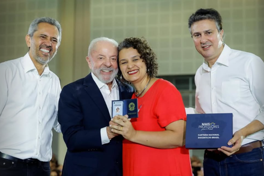 Imagem: Da esquerda para a direita: Governador Elmano de Freitas, presidente Luiz Inácio Lula da Silva, professora Glícia Pontes (estes dois últimos posando com a carteira docente na mão) e ministro Camilo Santana. 