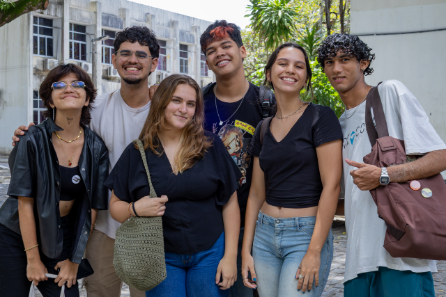 Os estudantes beneficiados receberão mensalmente o valor de R$500 e terão isenção parcial da taxa do Restaurante Universitário (Foto: Guilherme Silva/UFC) Imagem: Seis estudantes posando para foto no campus da UFC